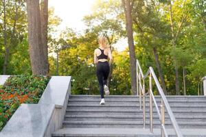 sport e fitness. in forma donna in esecuzione su il passaggi estate soleggiato mattina caucasico atletico femmina jogging all'aperto cardio formazione attivo salutare stile di vita foto