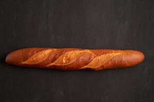 uno croccante francese baguettes menzogna su un vecchio di legno tavolo con gratuito spazio per testo foto