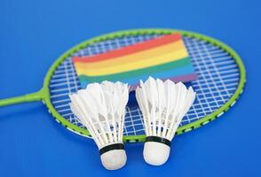 badminton volani, arcobaleno colori bandiera su racchetta. concetto, sport, esercizio, ricreazione attività per bene Salute. popolare sport per tutti generi e LGBTQ In tutto il mondo. foto