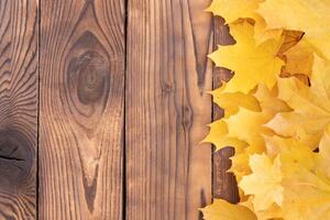 autunno le foglie telaio su di legno sfondo superiore Visualizza autunno confine giallo e arancia le foglie Vintage ▾ legna tavolo copia spazio per testo. foto