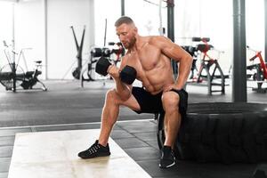 Palestra atleta bicipite esercizio manubrio muscolare uomo sedersi ruota Tenere sollevamento bilanciere. foto