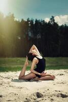 bellissimo ragazza è impegnato nel yoga nel il foresta su il sabbia foto