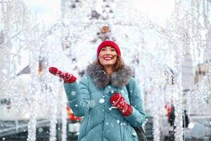 bellissimo bello di mezza età ragazza con Riccio capelli caldo inverno giacche sta ghiaccio pista sfondo cittadina quadrato. foto