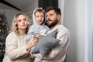 contento famiglia concetto. marito abbraccio pancia incinta moglie in piedi interno vivente camera vicino divano foto