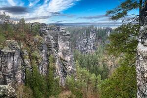 aspro rocce su il basteibridge. largo Visualizza al di sopra di alberi e montagne. nazionale parco foto