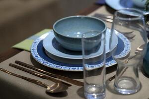 ambientazione su sofisticato tavoli con vario tipi di ciotole, piatti e bicchieri foto