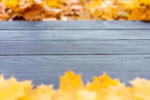 vuoto di legno tavolo natura bokeh sfondo con autunno giallo acero foglia pensionante modello finto su per Schermo di Prodotto copia spazio foto