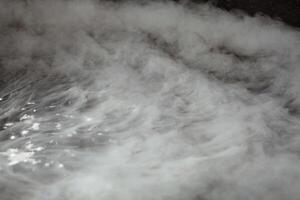 di spessore bianca Fumo su un' sfondo di nero ceramica piastrelle. foto