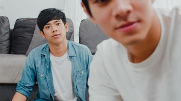 giovane coppia gay asiatica influencer coppia vlog a casa. gli uomini lgbtq coreani adolescenti si rilassano felici e si divertono usando il video del vlog della registrazione della fotocamera nei social media mentre si trovano sul divano nel soggiorno al concetto di casa. foto