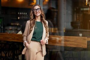 attività commerciale donna ristorante proprietario vestito elegante tailleur in piedi vicino ristorante grande finestra foto