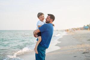 padre figlio la spesa tempo insieme mare vacanza giovane papà bambino poco ragazzo a piedi spiaggia foto