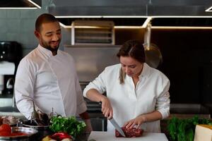 bello giovane africano capocuoco è cucinando insieme con il suo caucasico fidanzata nel il cucina utilizzando rosso vino come un ingrediente. foto