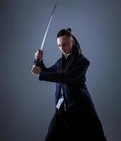 giovane uomo Tenere un' samurai spada. fascino foto. foto