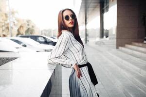 estate soleggiato stile di vita moda ritratto di giovane elegante fricchettone donna a piedi su il strada, indossare carino di moda attrezzatura foto