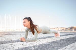 pieno lunghezza, forte in forma ragazza abbigliamento sportivo formazione tavola all'aperto foto