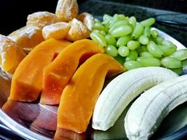 piatto con diverso frutta su cucina tavolo foto