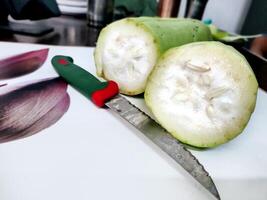 affettato bottiglia zucca con coltello su il tavolo foto