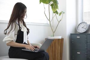un' Lavorando giapponese donna di a distanza opera nel il casa ufficio avvicinamento foto