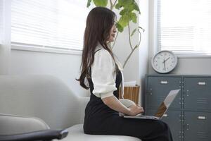 un' Lavorando giapponese donna di a distanza opera nel il casa ufficio avvicinamento foto