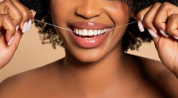 avvicinamento di nero donna filo interdentale, in mostra salutare denti foto