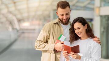 giovane contento coppia controllo passaporti e Biglietti mentre in attesa a aeroporto foto