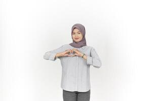 giovane asiatico donna indossare hijab mostrando amore cuore cartello isolato su bianca sfondo foto