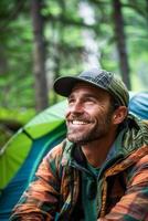 ai generato uomo sorridente mentre scrutare su a partire dal un' verde tenda nel un' lussureggiante foresta a alba foto