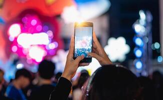 persone Tenere inteligente Telefono e registrazione e Fotografare nel concerto , silhouette di mani con mobile , evento sfondo concetto foto