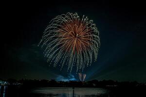 fuochi d'artificio sul fiume nel cielo scuro foto