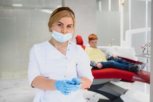 femmina dentista e bambino nel un' dentista ufficio foto