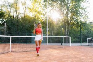 donna giocando tennis a il Tribunale e Tenere racchetta foto