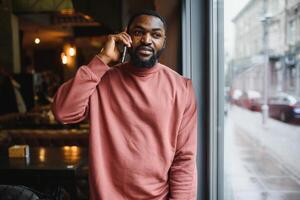 maturo africano americano uomo parlando di Telefono nel bar. foto