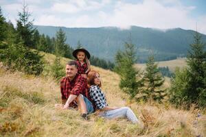 giovane famiglia con bambino riposo su un' montagna foto