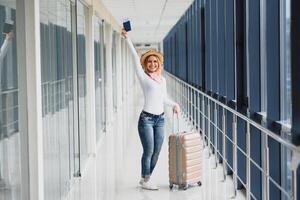 pronto per il viaggio. donna hold passaporto nel mano con bagaglio su aeroporto sfondo. alto stagione e vacanza concetto. rilassare e stili di vita foto