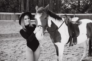 contento alla moda giovane donna in posa con un' cavallo su il spiaggia foto
