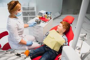 ragazzo soddisfatto con il servizio nel il dentale ufficio. concetto di pediatrico dentale trattamento foto