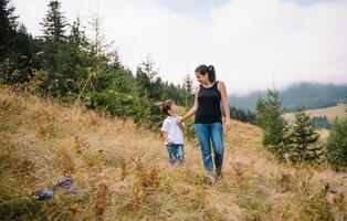 giovane mamma con bambino ragazzo in viaggio. madre su escursioni a piedi avventura con bambino, famiglia viaggio nel montagne. nazionale parco. escursione con bambini. attivo estate vacanze. foto