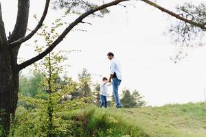 padre e figlio avere divertimento insieme nel natura. padre e figlio giocando. persone avendo divertimento all'aperto. concetto di amichevole famiglia. foto