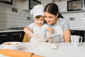 contento famiglia. madre insegnamento sua figlio Come per cucinando torta menù nel mattina. salutare stile di vita concetto.. cottura al forno Natale torta e cucinare concetto foto