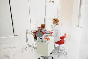 femmina dentista e bambino nel un' dentista ufficio foto