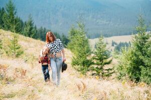 mamma abbracci un' poco figlia a il superiore di il montagna. quadrato. il concetto di famiglia, yoga, viaggio. foto