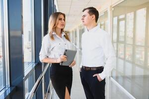 partner commerciali fiduciosi che scendono nell'edificio per uffici e discutono di lavoro foto