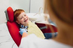 ragazzo soddisfatto con il servizio nel il dentale ufficio. concetto di pediatrico dentale trattamento foto