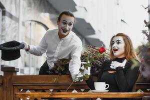 mimo tipo e ragazza nel bar potabile caffè. mimo nel davanti di Parigi bar recitazione piace potabile tè o caffè. foto