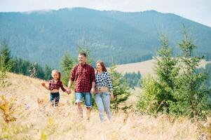 giovane famiglia con bambino riposo su un' montagna. vacanza nel il nazionale parco foto