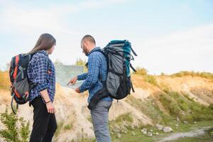 Due backpackers godendo scenario natura Visualizza mentre escursioni a piedi nel nazionale parco. coppia di escursionisti pianificazione Il prossimo modo per Esplorare Tenere carta geografica durante viaggio. infografica illustrazione carta geografica con superiore destinazioni foto