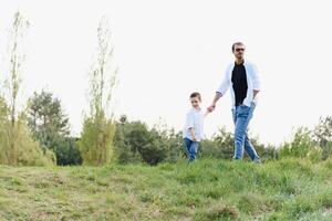 padre e figlio avere divertimento insieme nel natura. padre e figlio giocando. persone avendo divertimento all'aperto. concetto di amichevole famiglia. foto