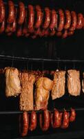 affumicato tradizionale affumicato carne. un' composizione di affumicato freddo tagli su un' nero sfondo. foto