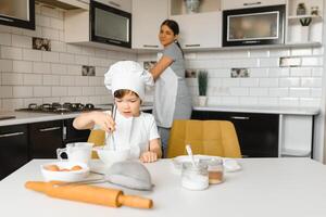 contento famiglia. madre insegnamento sua figlio Come per cucinando torta menù nel mattina. salutare stile di vita concetto.. cottura al forno Natale torta e cucinare concetto foto