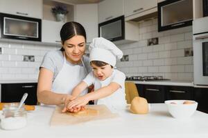 contento madre e poco figlio nel il cucina, contento tempo e solidarieta foto